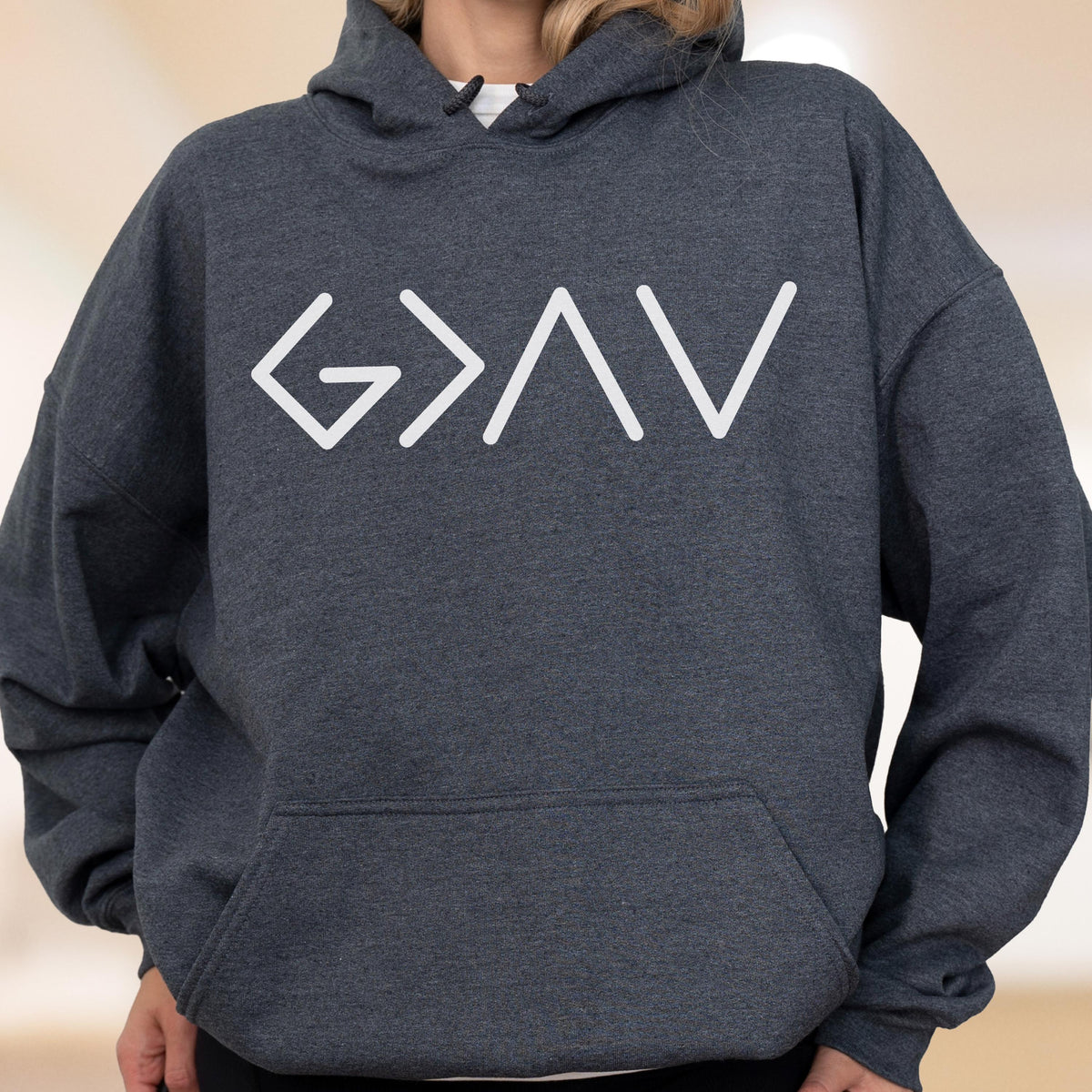 May include: Dark gray hoodie with a white graphic that reads "G>AV". The hoodie has a drawstring hood and a front pocket. The graphic is a minimalist design, with the letters outlined in white.