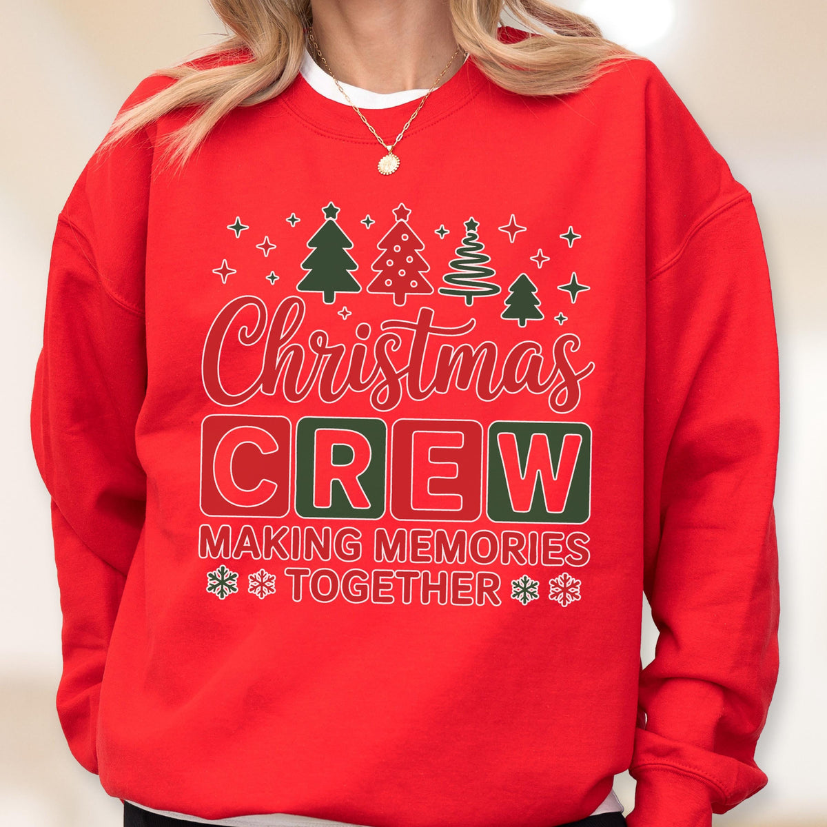 May include: A bright red crewneck sweatshirt featuring a graphic print with the text "Christmas CREW" in white and red, "MAKING MEMORIES TOGETHER" in white, and illustrations of green and white Christmas trees and snowflakes.