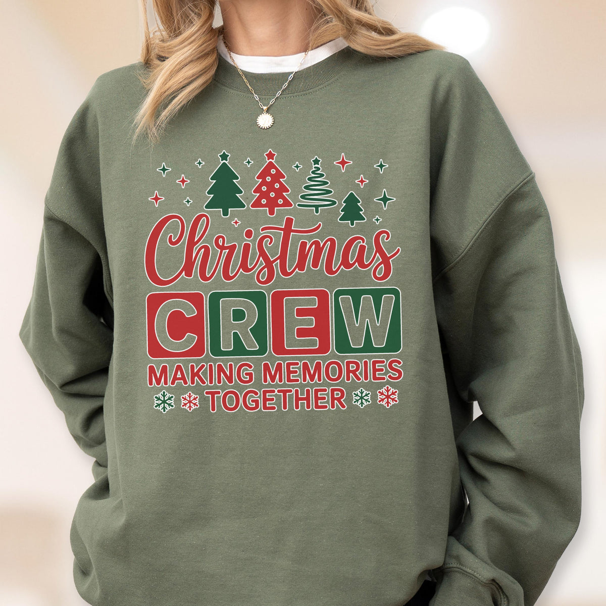 May include: An olive green crewneck sweatshirt featuring a graphic print with the text "Christmas CREW MAKING MEMORIES TOGETHER" in red, green, and white. The design includes stylized Christmas trees, stars, and snowflake icons.