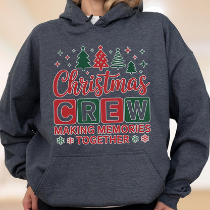 May include: A dark heather gray hooded sweatshirt featuring a graphic print with the text Christmas Crew Making Memories Together in red and white. The design includes green and red Christmas tree icons and white snowflake accents.