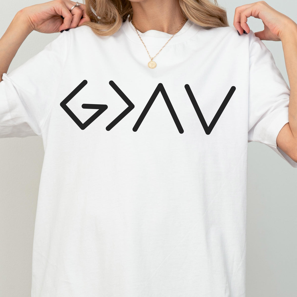 May include: A white short-sleeved t-shirt featuring a black graphic print on the chest. The design consists of the mathematical symbols G > AV, which are arranged horizontally in a clean, sans-serif font style across the center of the shirt.