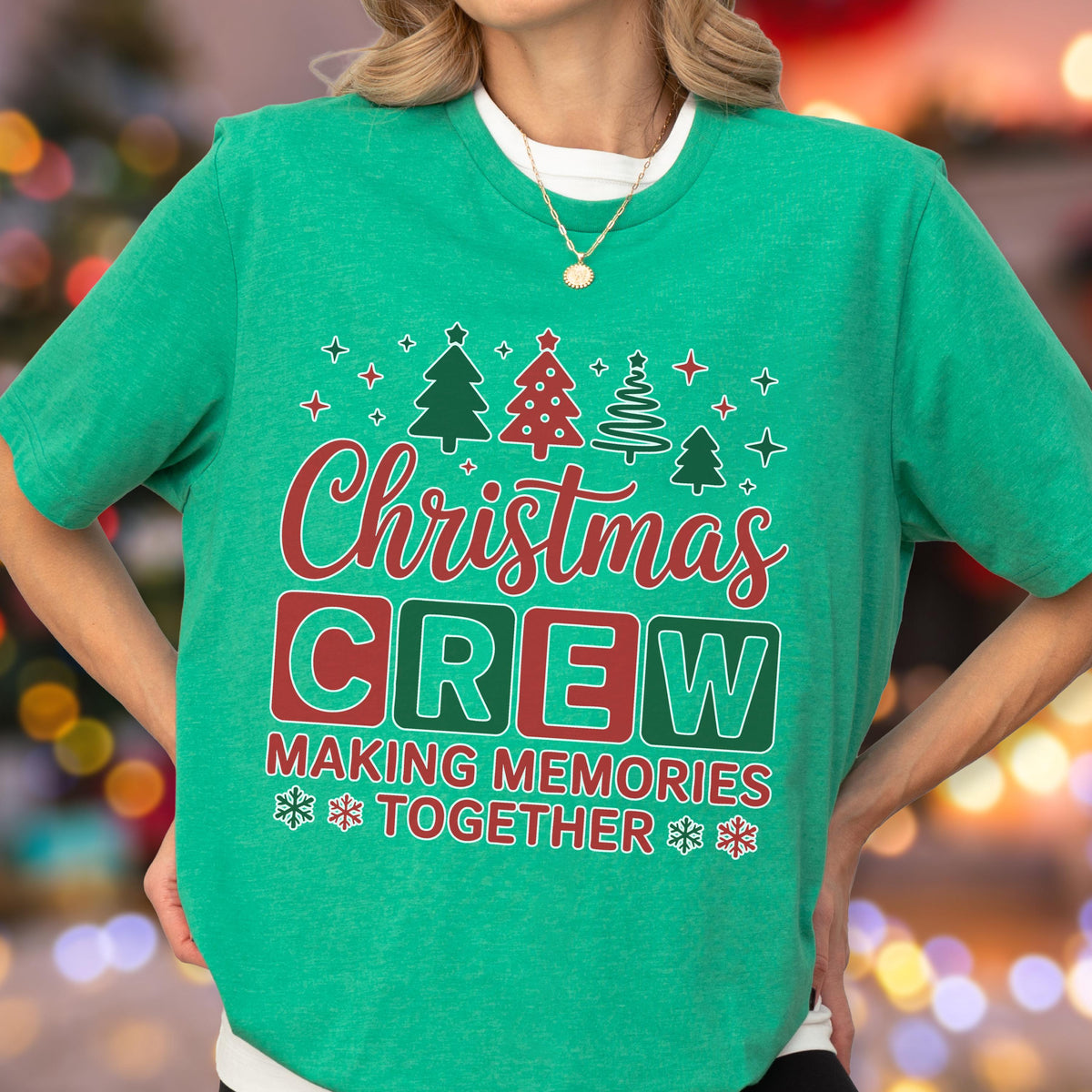 May include: A green short-sleeve t-shirt featuring a graphic with four stylized Christmas trees above the red text "Christmas" and the words "CREW" in large block letters, followed by "MAKING MEMORIES TOGETHER" and small snowflake icons.