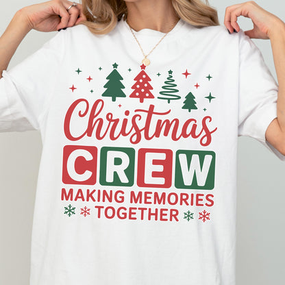 May include: A white t-shirt featuring a festive graphic with red and green Christmas trees and stars at the top. The text reads Christmas CREW in large red and green block letters, followed by the red text MAKING MEMORIES TOGETHER with snowflakes.