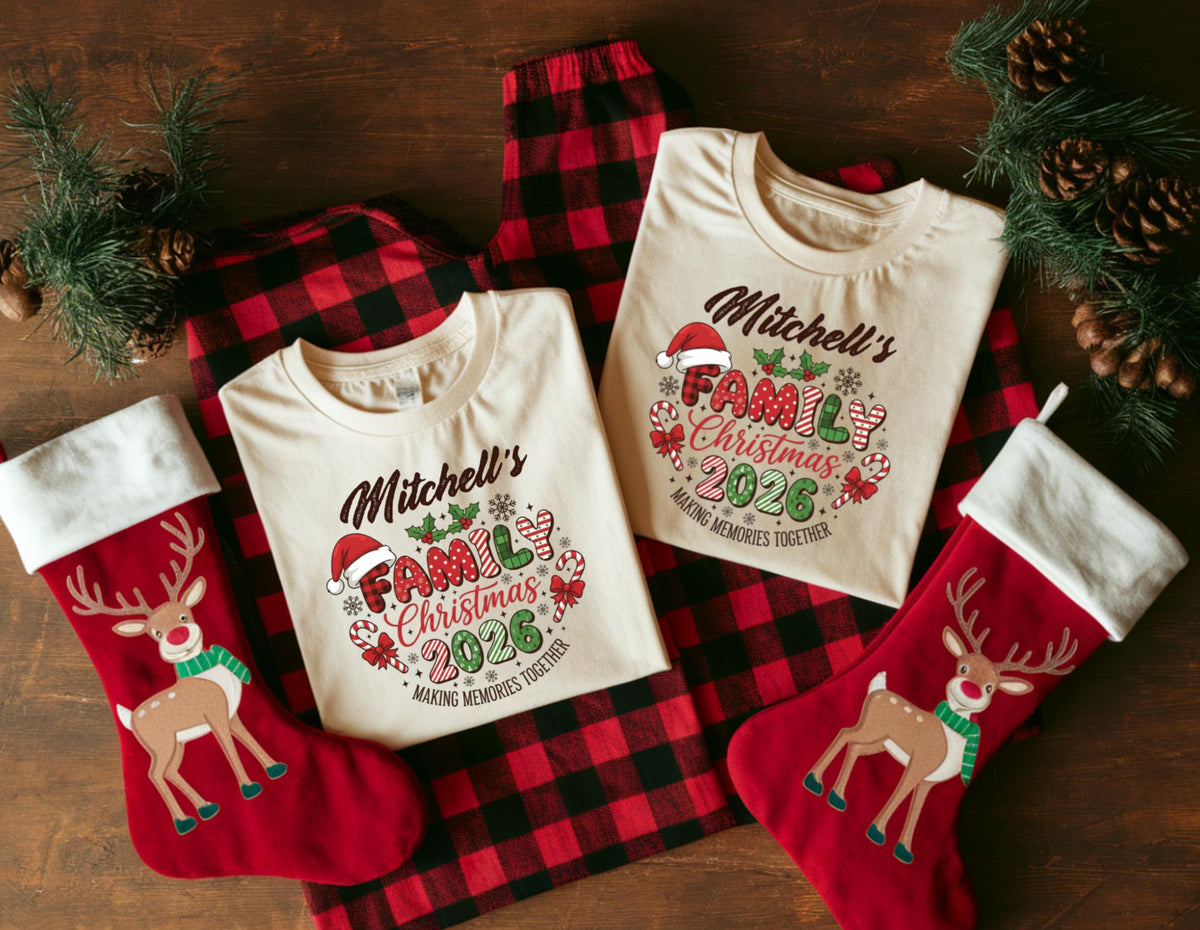 May include: A festive Christmas family pajama set featuring two cream-colored t-shirts with the text "Mitchell's Family Christmas 2026" and matching red plaid pajama pants. Includes two red Christmas stockings with reindeer designs.
