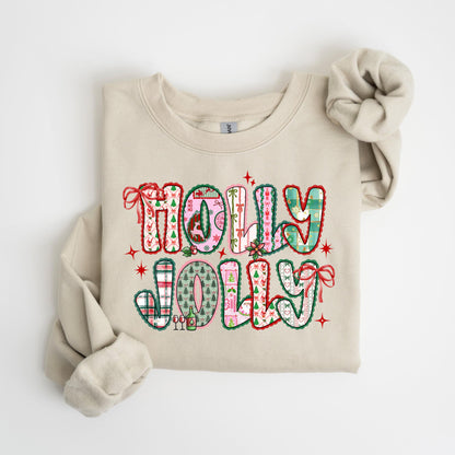 May include: A beige sweatshirt with the words "HOLLY JOLLY" in a colorful, patterned design. The letters are outlined in green and red, with various holiday-themed patterns inside, including plaid, trees, and bows. Red stars and bows accent the design.