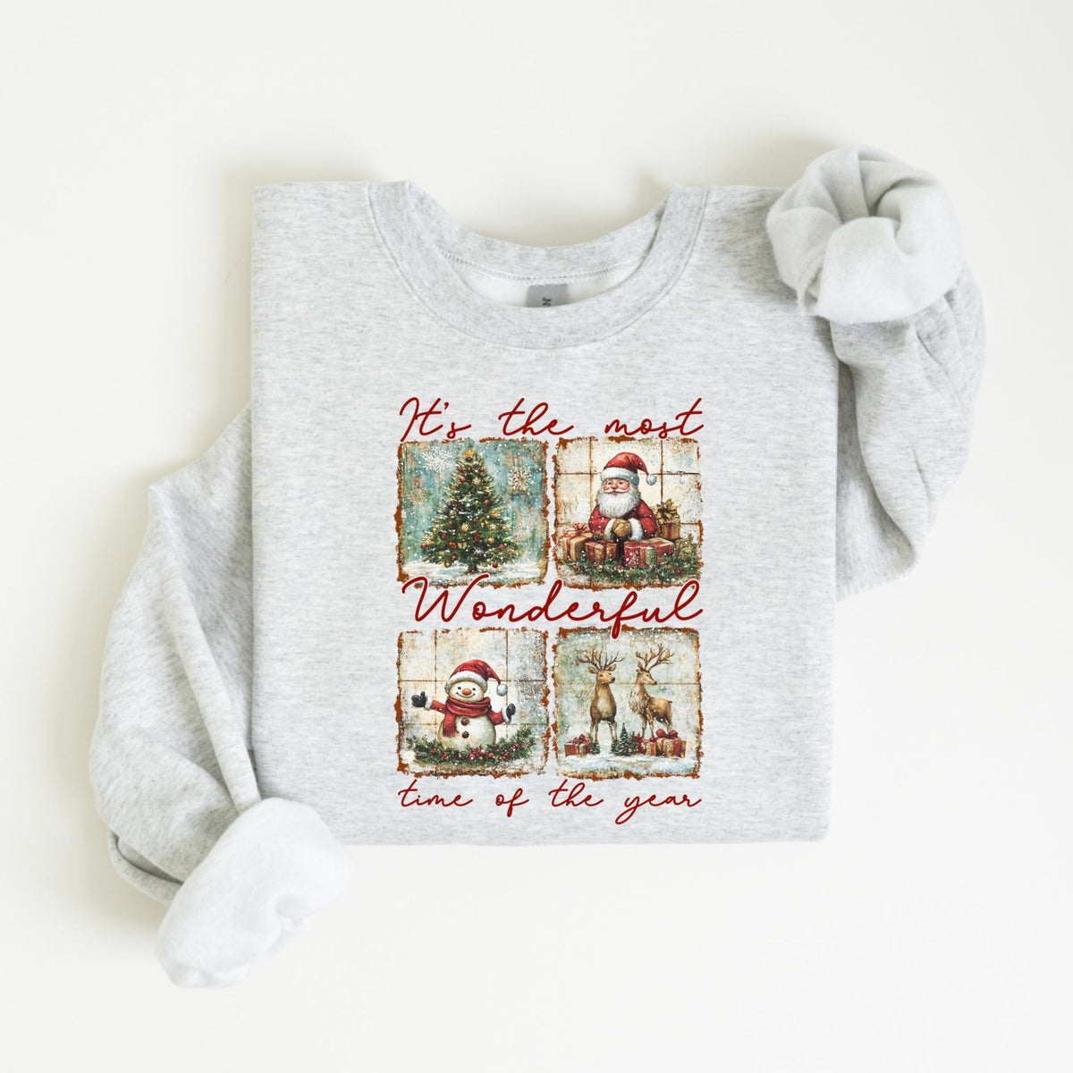 May include: Light gray sweatshirt with a festive Christmas design. The design features a Christmas tree, Santa Claus, a snowman, and reindeer. The text "It's the most Wonderful time of the year" is also included.