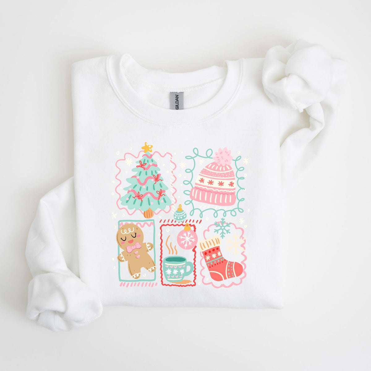 May include: White sweatshirt featuring a festive design with a Christmas tree, a pink knit hat, a gingerbread man, a mug of hot cocoa, and a Christmas stocking. The illustrations are in pastel colors with decorative borders, perfect for the holiday season.