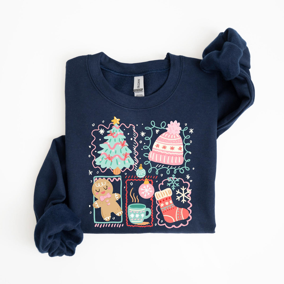 May include: Navy blue sweatshirt featuring a colorful Christmas-themed graphic. The design includes a Christmas tree, a pink beanie, a gingerbread man, a mug of hot cocoa, and a Christmas stocking. The graphic is framed with decorative borders and snowflakes.
