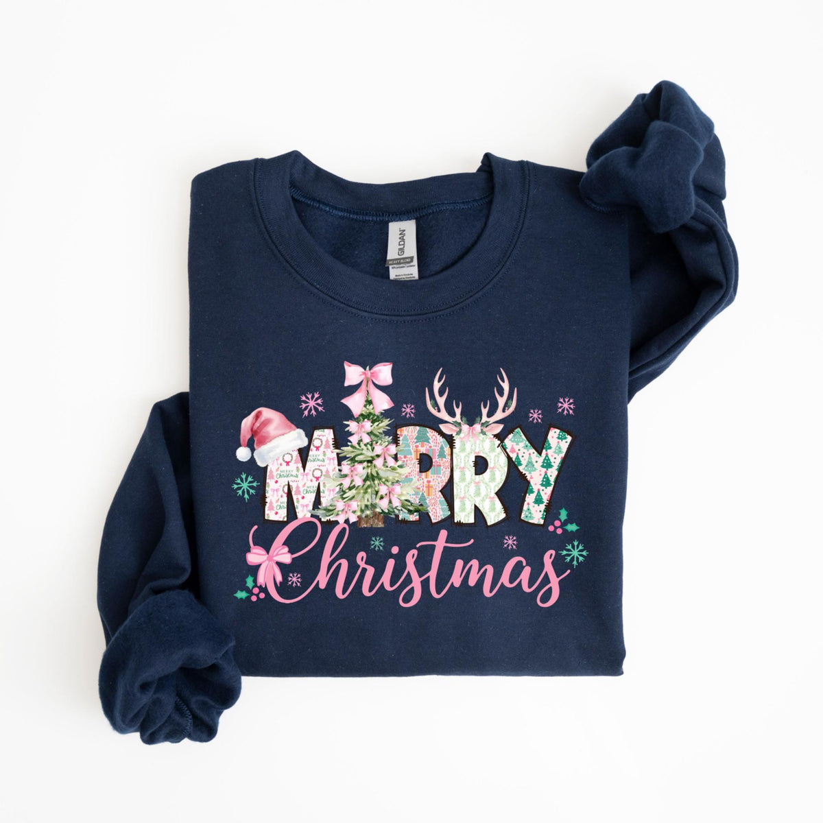 May include: Navy blue sweatshirt with a festive "Merry Christmas" design. The design features a Christmas tree, reindeer antlers, snowflakes, and a Santa hat, all in a floral pattern. The text "Merry Christmas" is in pink script.