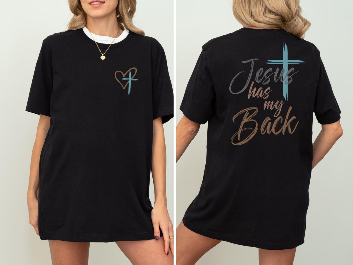 May include: Black t-shirt with a white collar and a gold necklace. The front features a heart and cross design. The back of the shirt displays the text "Jesus has my Back" with a cross graphic. The shirt is a casual, comfortable style.