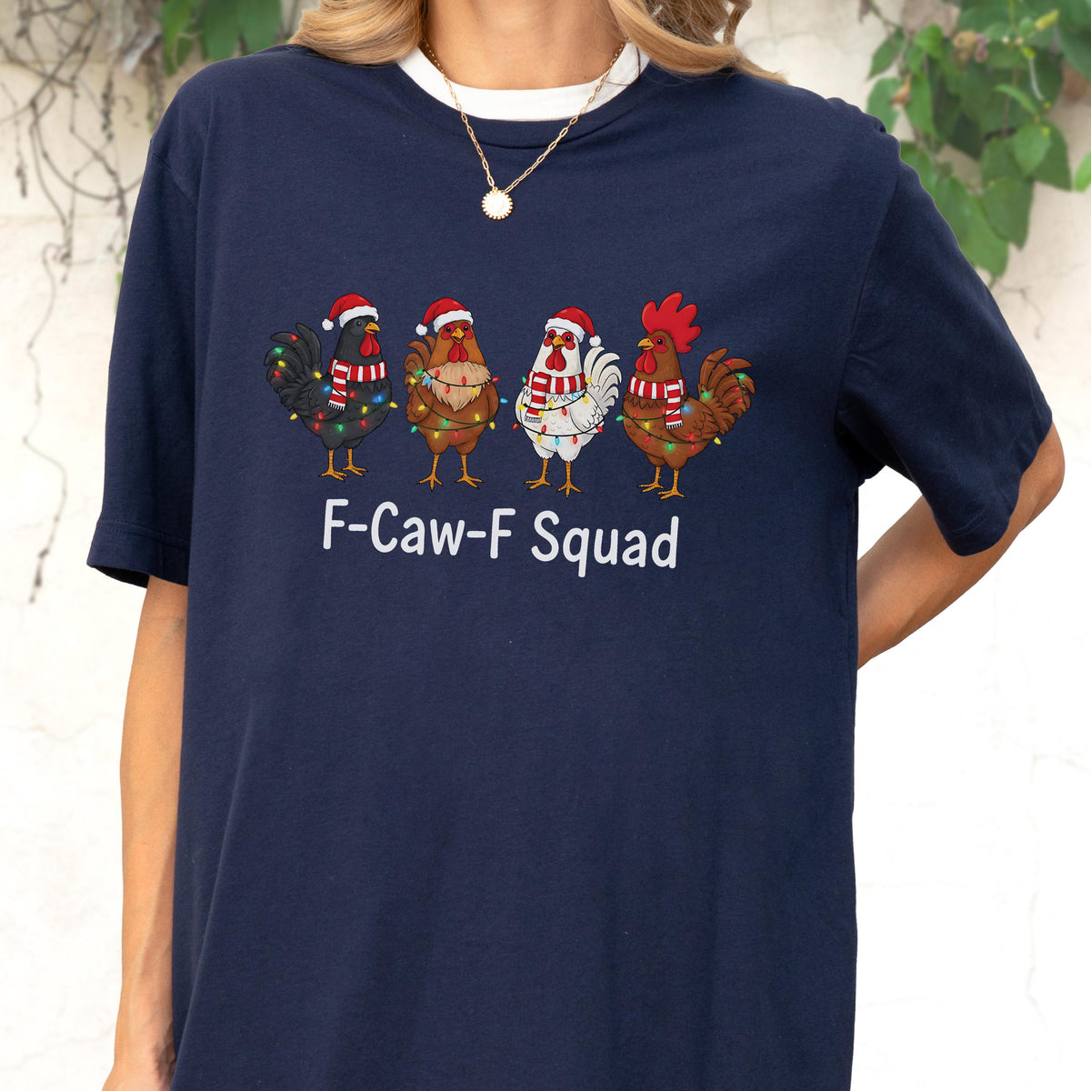 May include: Navy blue t-shirt with a white collar featuring a festive design. The graphic shows four cartoon roosters wearing Santa hats and Christmas lights, with the text "F-Caw-F Squad" below.