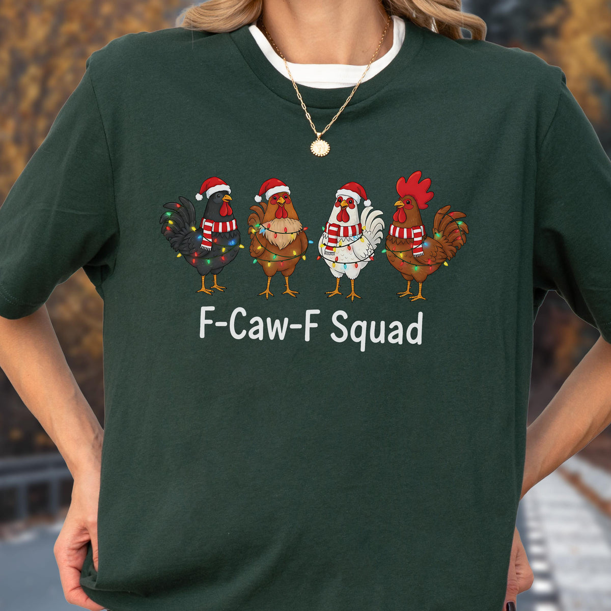 May include: Dark green t-shirt featuring a festive design with four cartoon roosters wearing Santa hats and Christmas lights. The text "F-Caw-F Squad" is printed below the roosters in white.