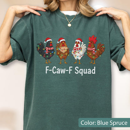 May include: Blue spruce-colored t-shirt featuring a graphic of four chickens wearing Santa hats and scarves, adorned with Christmas lights. The text "F-Caw-F Squad" is printed below the chickens. The shirt is a solid color.