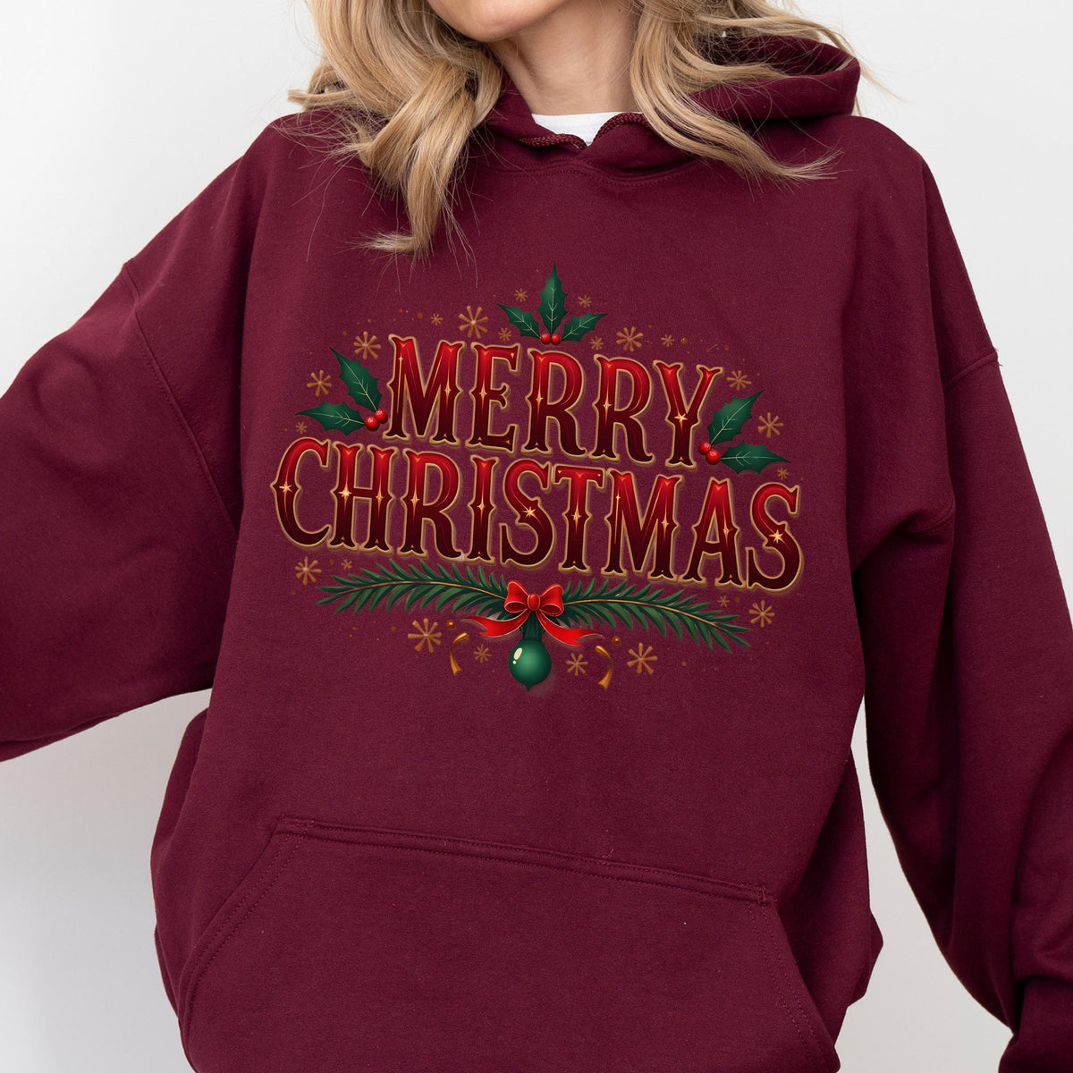 May include: Burgundy hooded sweatshirt with the text "MERRY CHRISTMAS" in red and green. The text is surrounded by festive holiday elements, including holly leaves, berries, snowflakes, and a green ornament with a red bow.