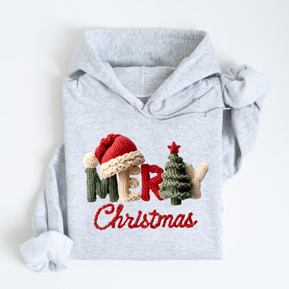 May include: A light gray hoodie with the words "Merry Christmas" in red script. The letters are decorated with a Santa hat, a Christmas tree, and other festive elements, all in a knitted style.