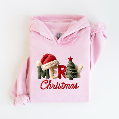 May include: A light pink hoodie with a festive embroidered design. The design features the word "MER" with a Santa hat, a Christmas tree, and the word "Christmas" in red thread. The hoodie has a drawstring hood and long sleeves.