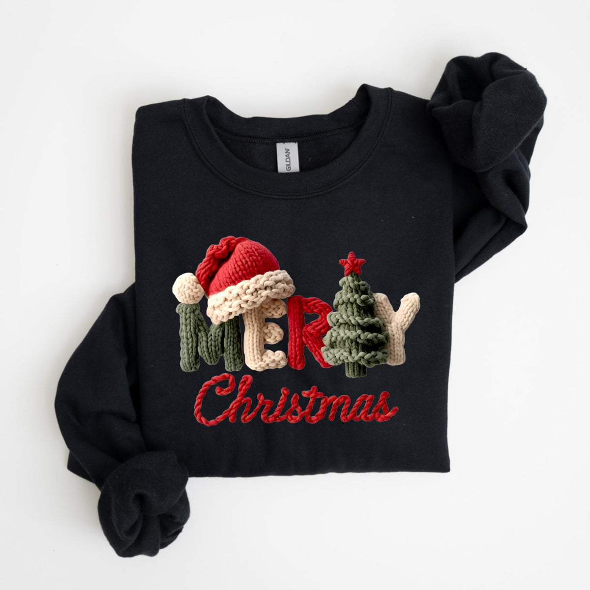 May include: Black sweatshirt with a knitted "Merry Christmas" design. The design includes a red Santa hat, a green Christmas tree, and the word "Merry" in a knitted style with red embroidered "Christmas" text.