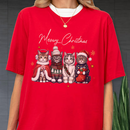 May include: A bright red t-shirt featuring the text Meowy Christmas in white script above a graphic of four cats wearing winter accessories including earmuffs, a knit hat, a scarf, and a Santa hat, surrounded by small yellow stars and snowflakes.