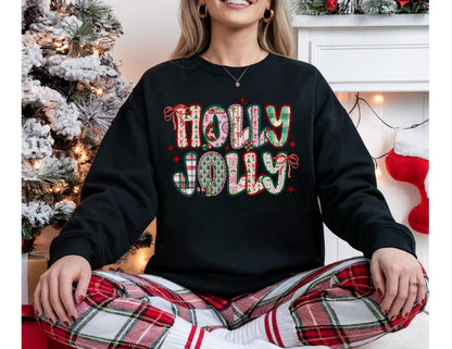 May include: Black sweatshirt with the words "HOLLY JOLLY" in a festive, colorful design. The letters are decorated with plaid, floral, and striped patterns, with red bows. The person is wearing red and white plaid pajama pants.