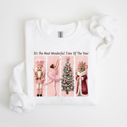 May include: White sweatshirt with a graphic featuring a nutcracker, ballerina, Christmas tree, and mouse king. The text "It's The Most Wonderful Time Of The Year" is printed above the characters. The design has pink and red accents.