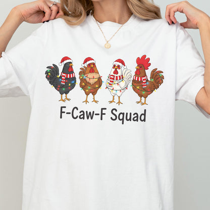 May include: White t-shirt featuring a graphic of four cartoon roosters wearing Santa hats and scarves, adorned with Christmas lights. The text "F-Caw-F Squad" is printed below the roosters. A festive and humorous design.