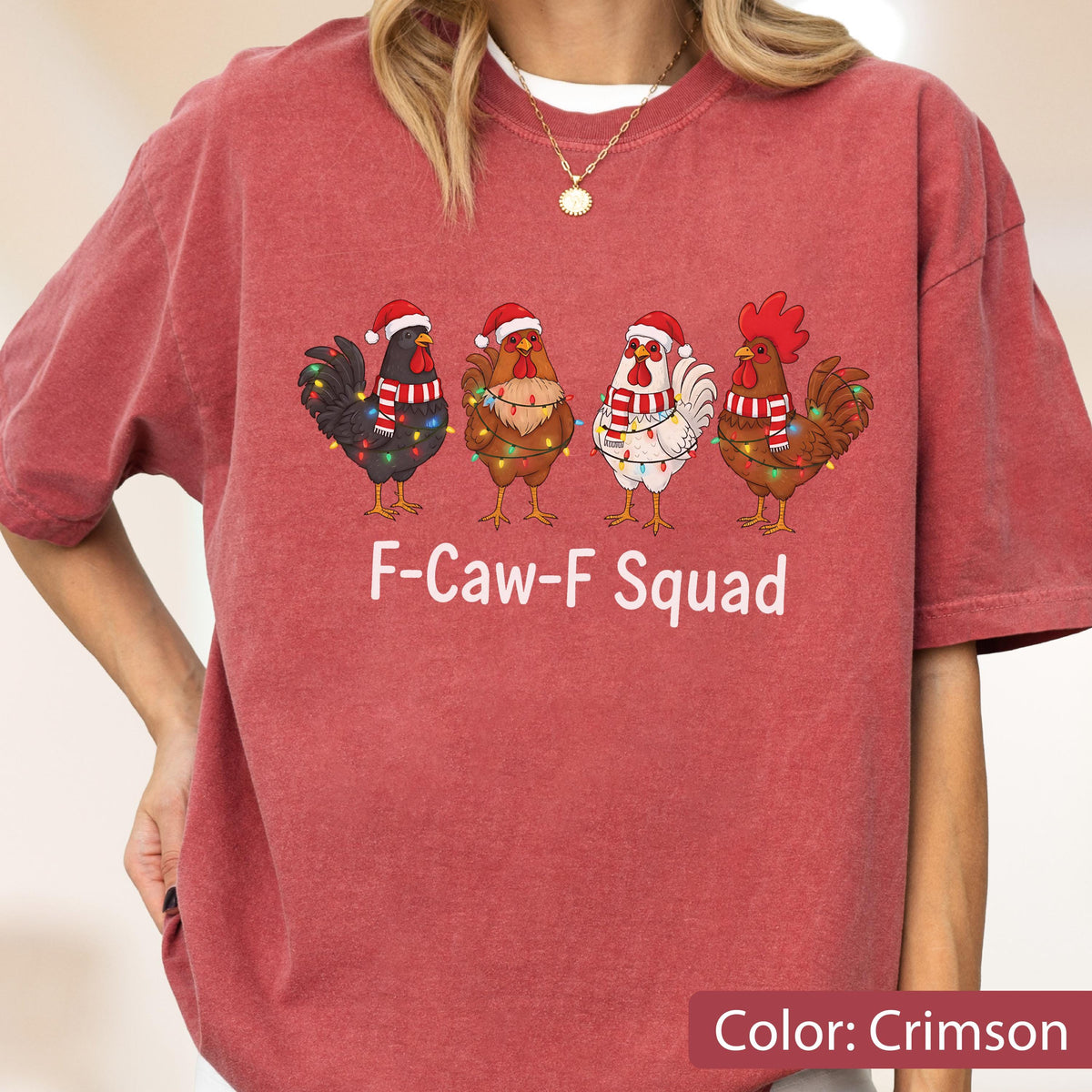 May include: Crimson-colored t-shirt featuring four cartoon roosters wearing Santa hats and scarves, adorned with Christmas lights. The text "F-Caw-F Squad" is printed below the roosters. The shirt is a solid crimson color.
