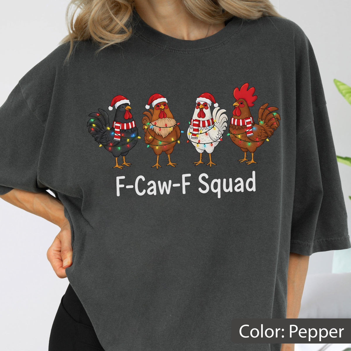 May include: Pepper-colored t-shirt featuring four cartoon chickens in Santa hats and scarves, each adorned with string lights. The text "F-Caw-F Squad" is printed below the chickens, creating a festive and humorous design.