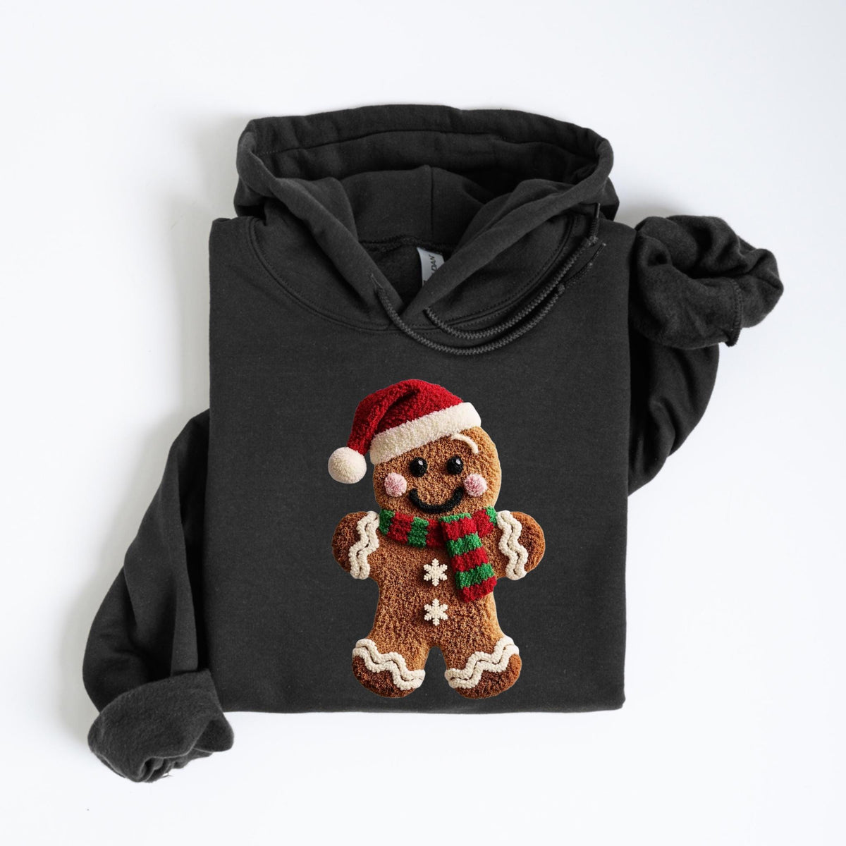 May include: Black hooded sweatshirt featuring a gingerbread man design. The gingerbread man wears a red Santa hat and a green and red striped scarf. The gingerbread man has a smiling face and two white snowflakes.