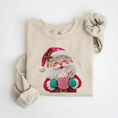 May include: Cream-colored sweatshirt featuring a festive Santa Claus design. Santa is depicted with a white beard, red suit, and hat, holding a pink mug with whipped cream and a candy cane. The design is detailed and colorful, perfect for the holiday season.