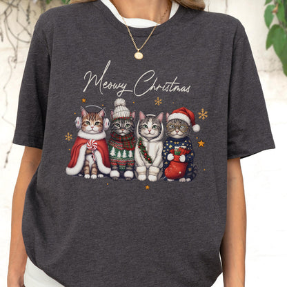 May include: A dark charcoal gray t-shirt featuring a graphic of four cats dressed in winter holiday attire. The text "Meowy Christmas" is printed above the cats, who are wearing earmuffs, a beanie, a hoodie, and a Santa hat with a stocking.
