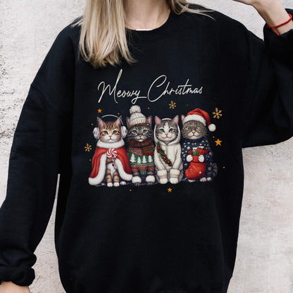 May include: A black long-sleeve sweatshirt featuring a graphic of four cats wearing winter accessories and the text Meowy Christmas. The cats are dressed in a red cape, a knit sweater, a white hoodie, and a blue sweater with a red stocking.