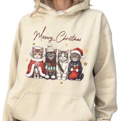 May include: A cream-colored hooded sweatshirt featuring a graphic of four cats dressed in winter holiday attire. The text "Meowy Christmas" is printed above the cats, who are wearing items like earmuffs, a beanie, a scarf, and a Santa hat.