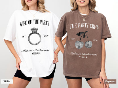 May include: Two oversized t-shirts, one white and one espresso, with graphic designs. The white shirt features a diamond ring graphic and the text "WIFE OF THE PARTY" and "Madison's Bachelorette VEGAS". The espresso shirt has a cherry graphic and reads "THE PARTY CREW".