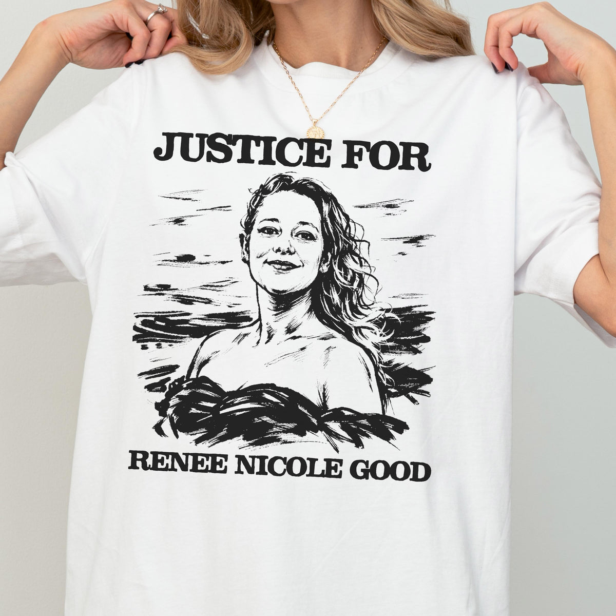May include: White t-shirt with the text "JUSTICE FOR" above a black and white portrait of a woman. Below the portrait is the text "RENEE NICOLE GOOD". The shirt is a casual style.