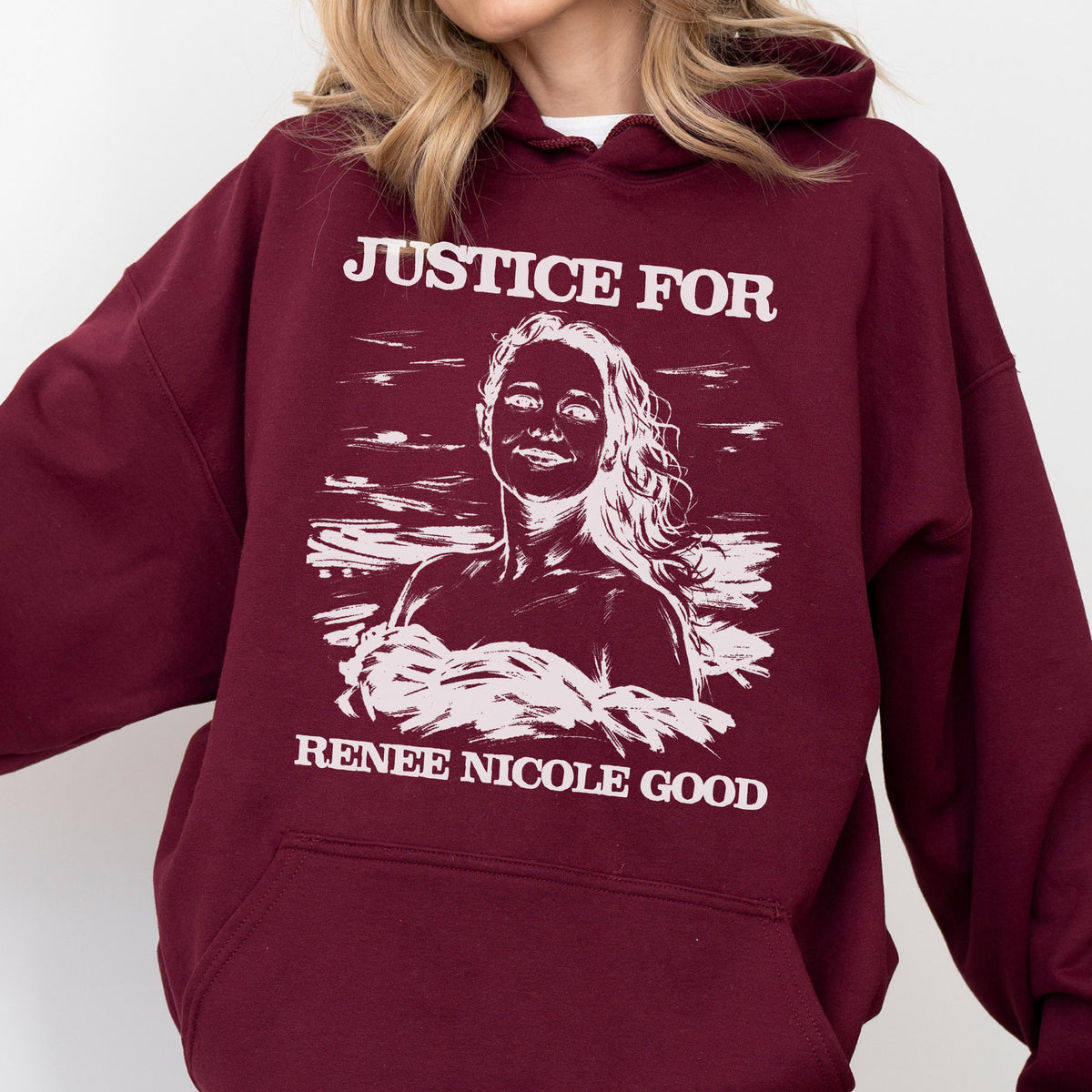 May include: Burgundy hoodie with the text "JUSTICE FOR" above a white illustration of a woman, and "RENEE NICOLE GOOD" below. The hoodie has a drawstring hood and a front pocket.