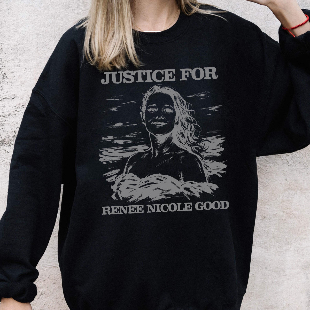 May include: Black sweatshirt with the text "JUSTICE FOR" above a grayscale portrait of a woman, with the text "RENEE NICOLE GOOD" below the portrait. The sweatshirt is a crew neck style.
