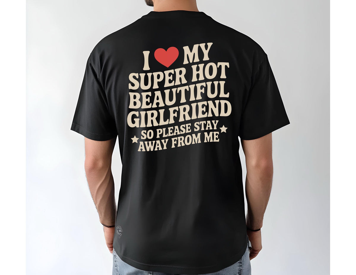 May include: Black t-shirt with the text "I ❤️ MY SUPER HOT BEAUTIFUL GIRLFRIEND SO PLEASE STAY AWAY FROM ME" in cream-colored letters and a red heart. The shirt is a short-sleeved crew neck.