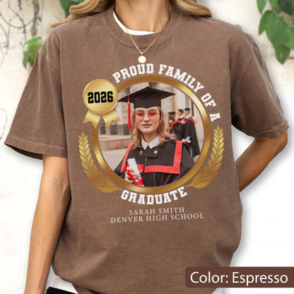 May include: Espresso-colored t-shirt with a graduation-themed design. The design includes a photo of a graduate, the text "Proud Family of a Graduate," the year 2026, and the graduate's name and high school.