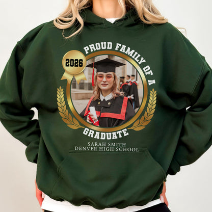 May include: Dark green hooded sweatshirt with a gold emblem featuring a graduate's photo, the text "Proud Family of a Graduate," and the year "2026." The graduate's name and high school are also displayed.