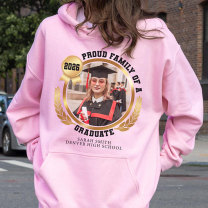 May include: Pink hooded sweatshirt with a graduation design. The design includes a photo of a graduate, the words "Proud Family of a Graduate", the year 2026, and the graduate's name and high school.