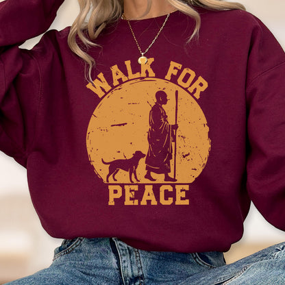 May include: Burgundy sweatshirt with a circular graphic featuring a person with a dog, walking with a staff. The graphic is in shades of yellow and brown, with the words "WALK FOR PEACE" in a circular arrangement.