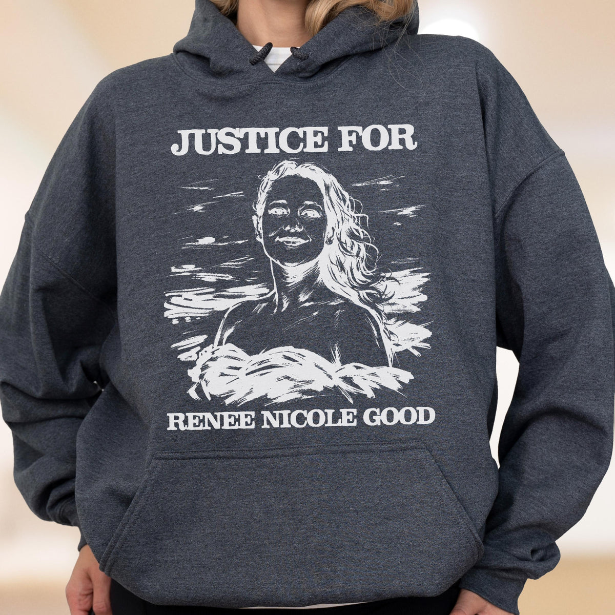 May include: Dark gray hoodie with a white graphic that reads "JUSTICE FOR" above a portrait of a woman and "RENEE NICOLE GOOD" below. The hoodie has a front pocket and a hood.