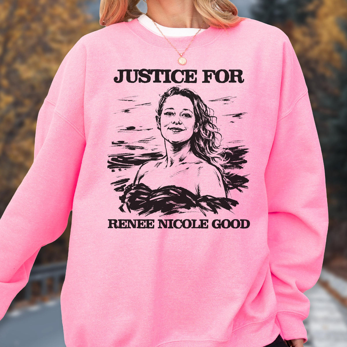 May include: A bright pink sweatshirt with the text "JUSTICE FOR" above a black and white illustration of a woman. Below the illustration is the text "RENEE NICOLE GOOD". The sweatshirt has long sleeves and a crew neck.