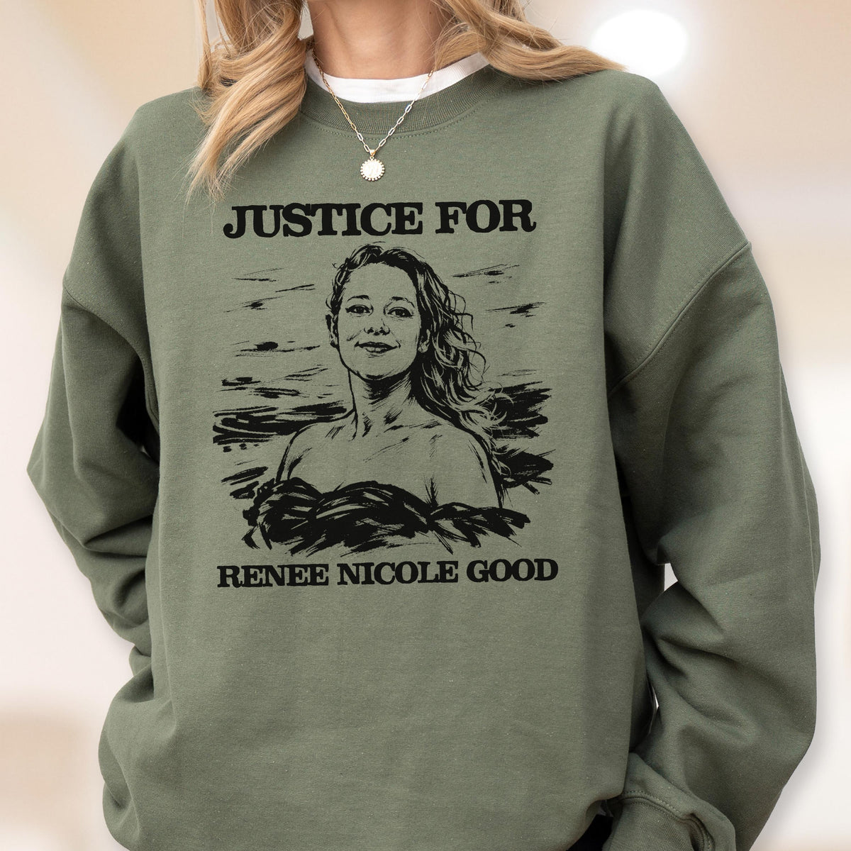 May include: An olive green sweatshirt with the text "JUSTICE FOR" above a black and white illustration of a woman. Below the illustration is the text "RENEE NICOLE GOOD".