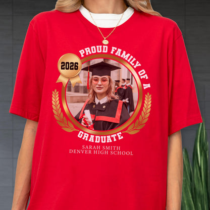 May include: Red t-shirt with a graduation design. The design includes a photo of a graduate in a cap and gown, the words "Proud Family of a Graduate," the year "2026," and the graduate's name and high school.