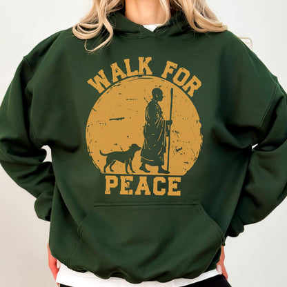 May include: Dark green hoodie with a front pocket and a drawstring hood. The front features a distressed gold graphic of a person with a dog, walking in front of a sun with the words "WALK FOR PEACE".