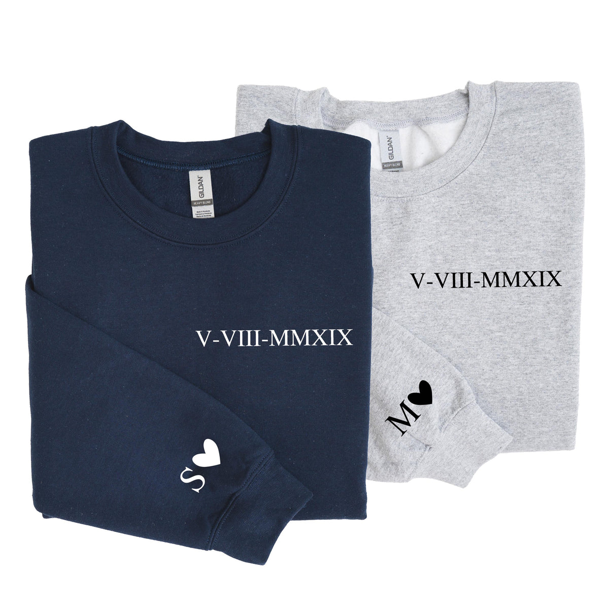 May include: A navy blue sweatshirt and a light gray sweatshirt, each featuring the Roman numeral date V-VIII-MMXIX printed on the chest. The navy sweatshirt has a white letter S and a heart on the sleeve, while the gray one has a black M and heart.