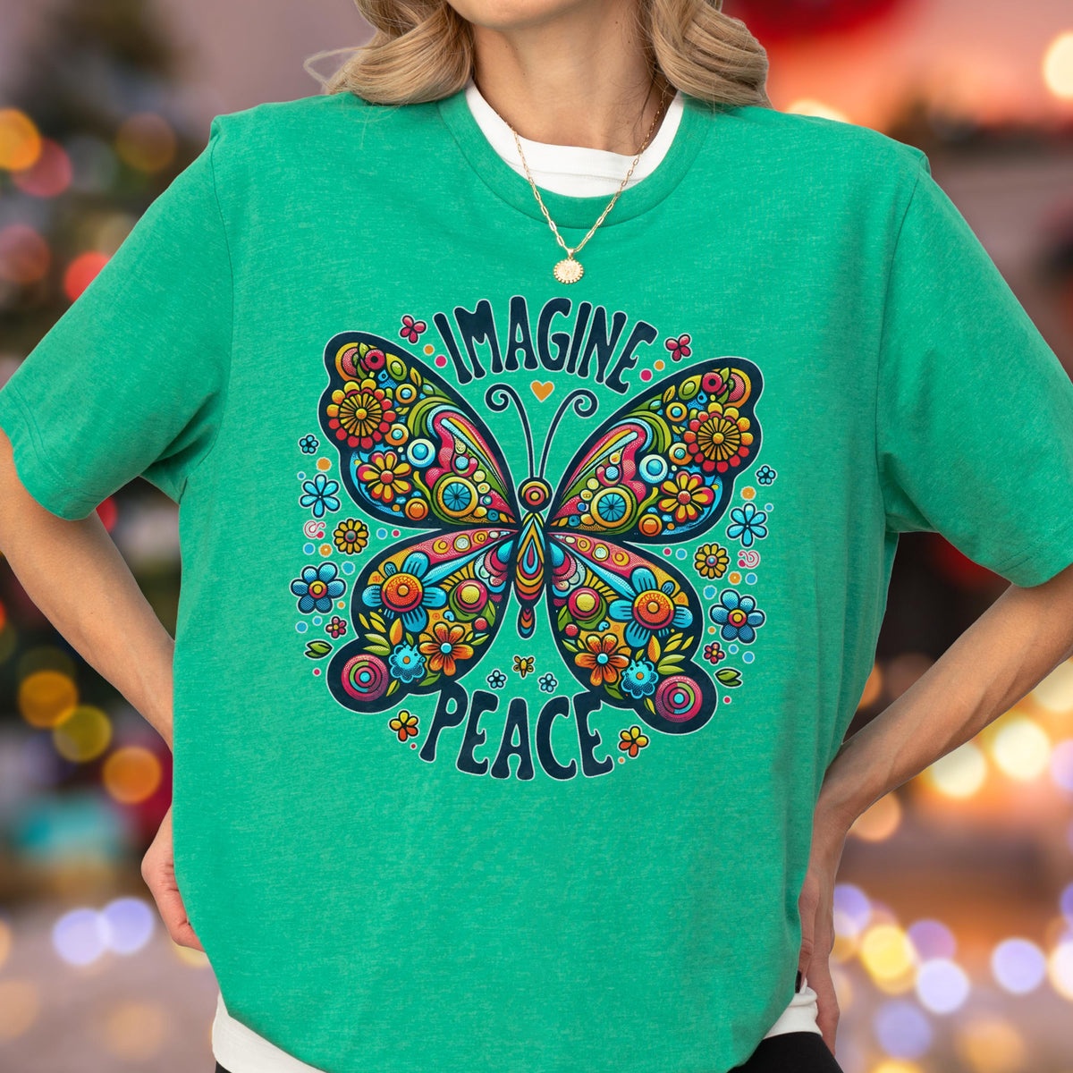 May include: A bright green short-sleeve t-shirt featuring a large, colorful butterfly graphic with intricate floral patterns. The text "IMAGINE" is arched above the butterfly, and the word "PEACE" is curved below it in a dark blue font.