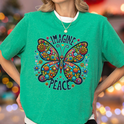 May include: A bright green short-sleeve t-shirt featuring a large, colorful butterfly graphic with intricate floral patterns. The text "IMAGINE" is arched above the butterfly, and the word "PEACE" is curved below it in a dark blue font.