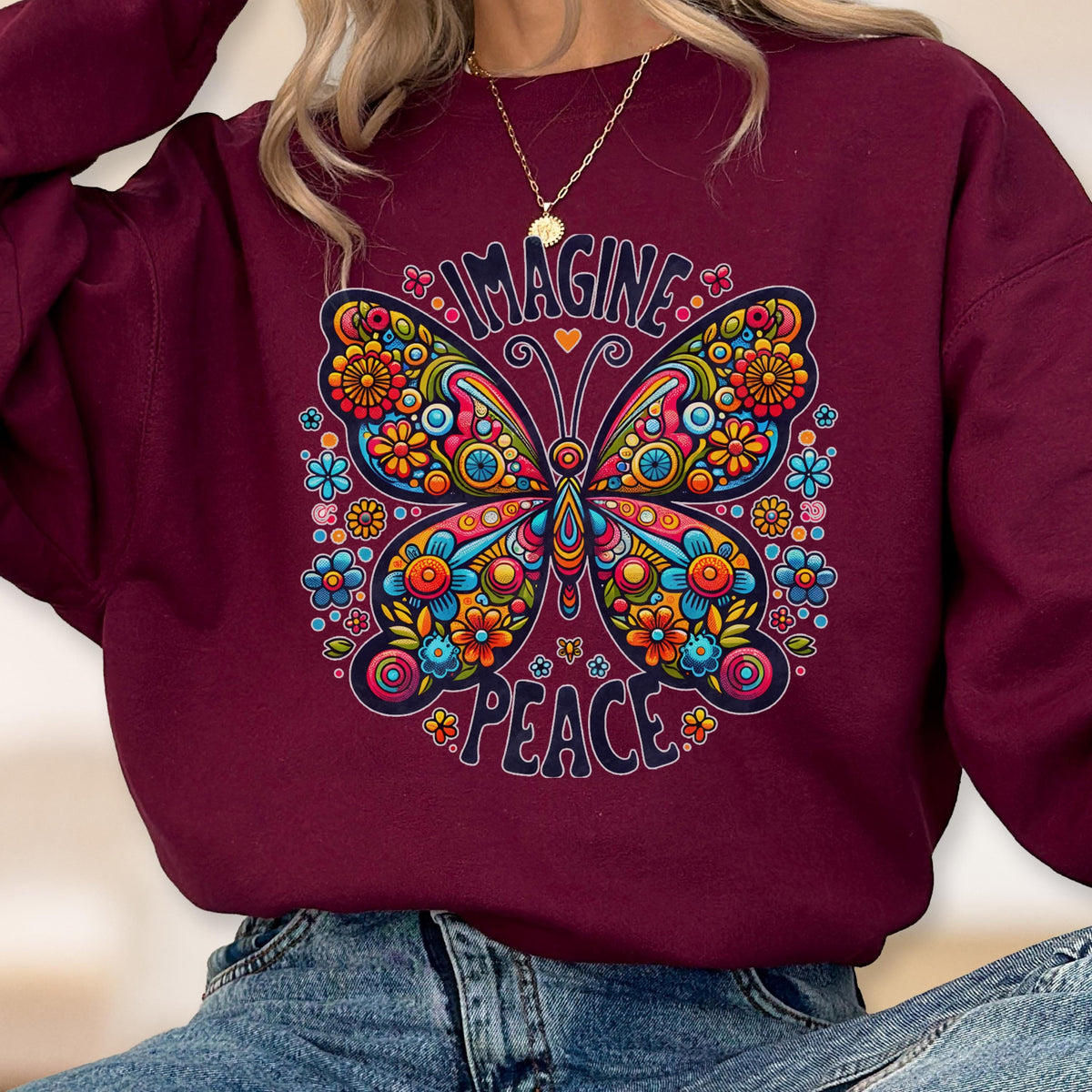 May include: Burgundy sweatshirt featuring a colorful butterfly design with the words "IMAGINE" and "PEACE" in a circular arrangement. The butterfly is adorned with flowers in shades of blue, orange, and yellow.